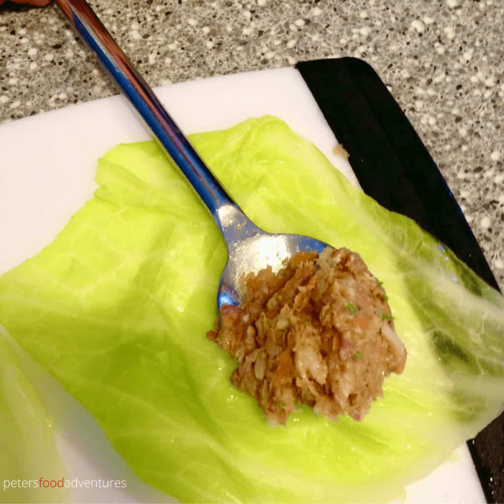 stuffing meat inside a cabbage leaf for golubtsi