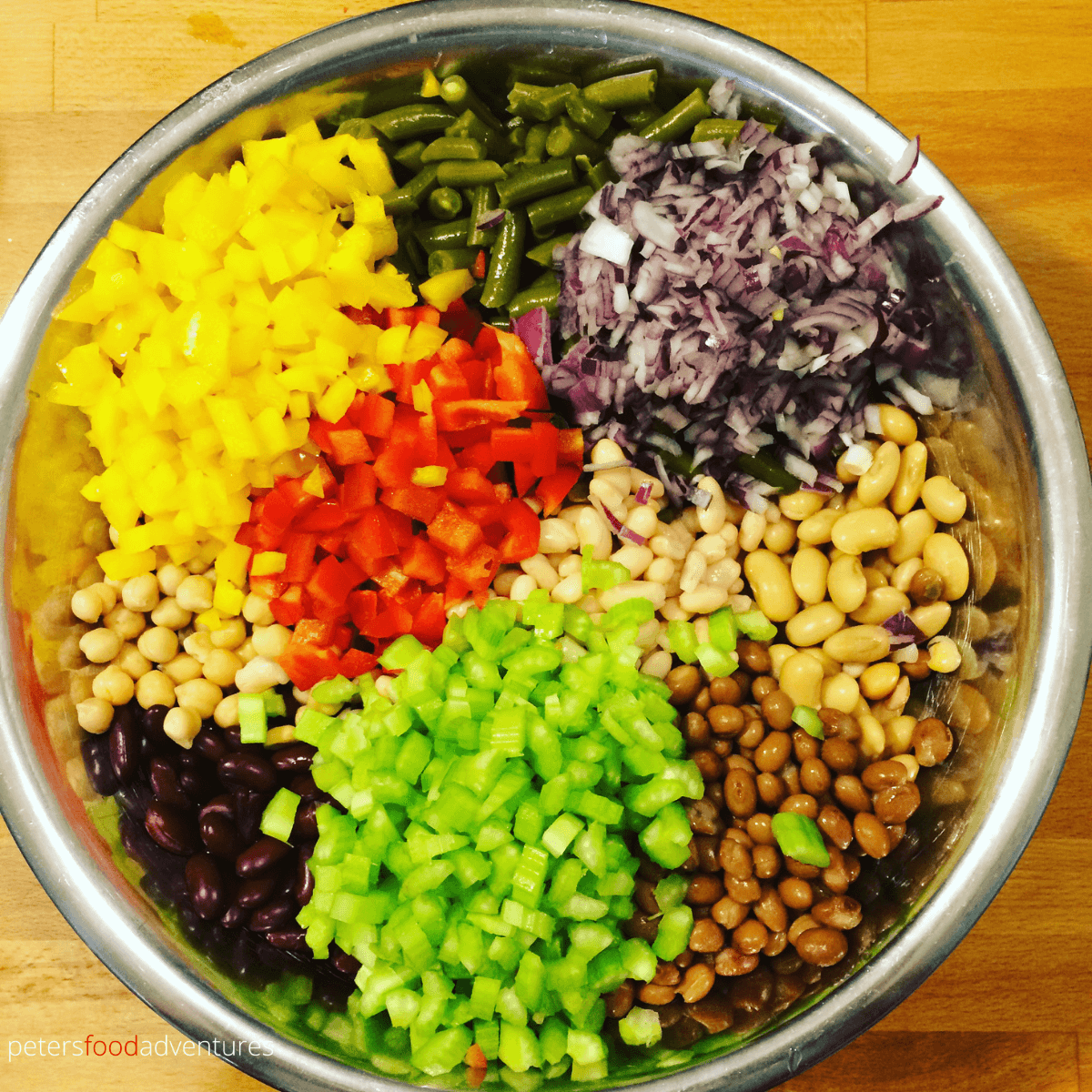 making 7 bean salad with canned bean, celery, red peppers in a large bowl