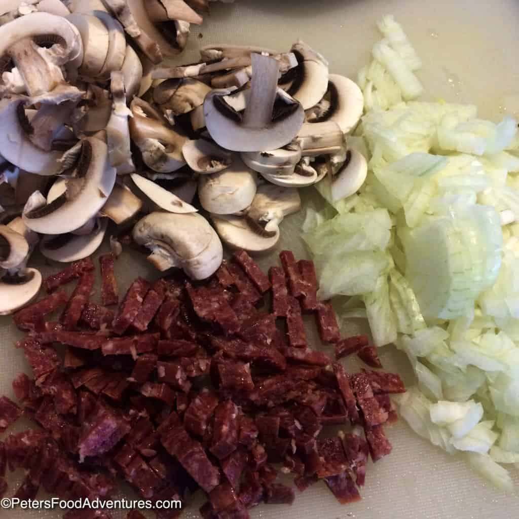 slicing mushrooms, kolbassa and onions