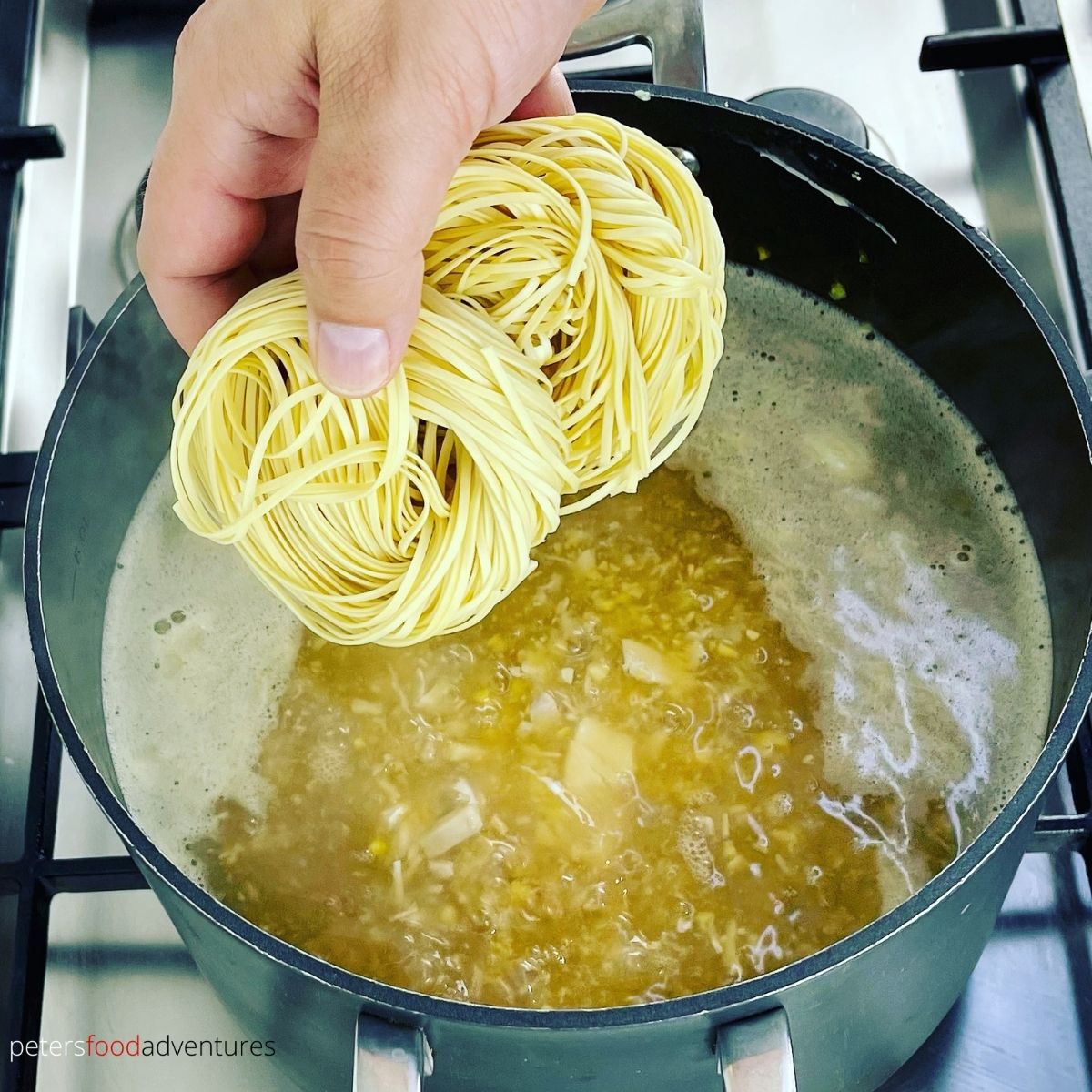 adding egg noodles to soup pot