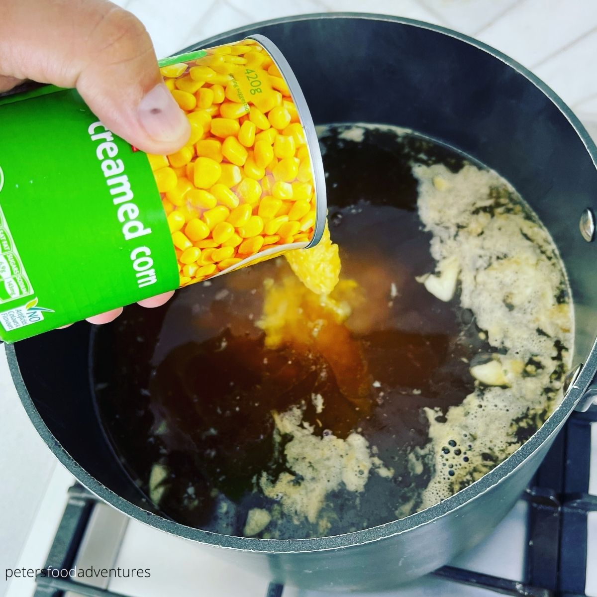 pouring creamed corn into soup