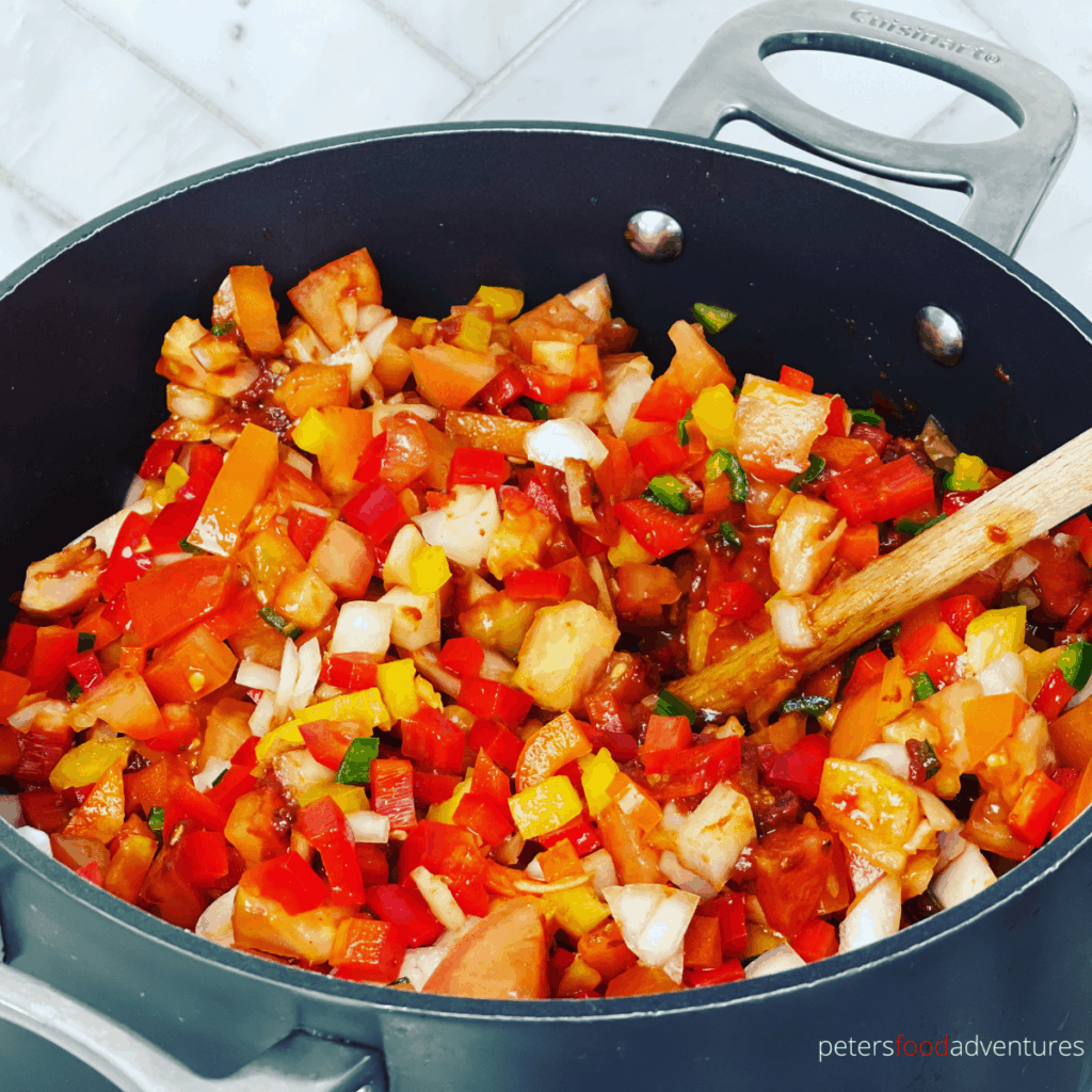 fresh chopped tomatoes and peppers in a pot making salsa