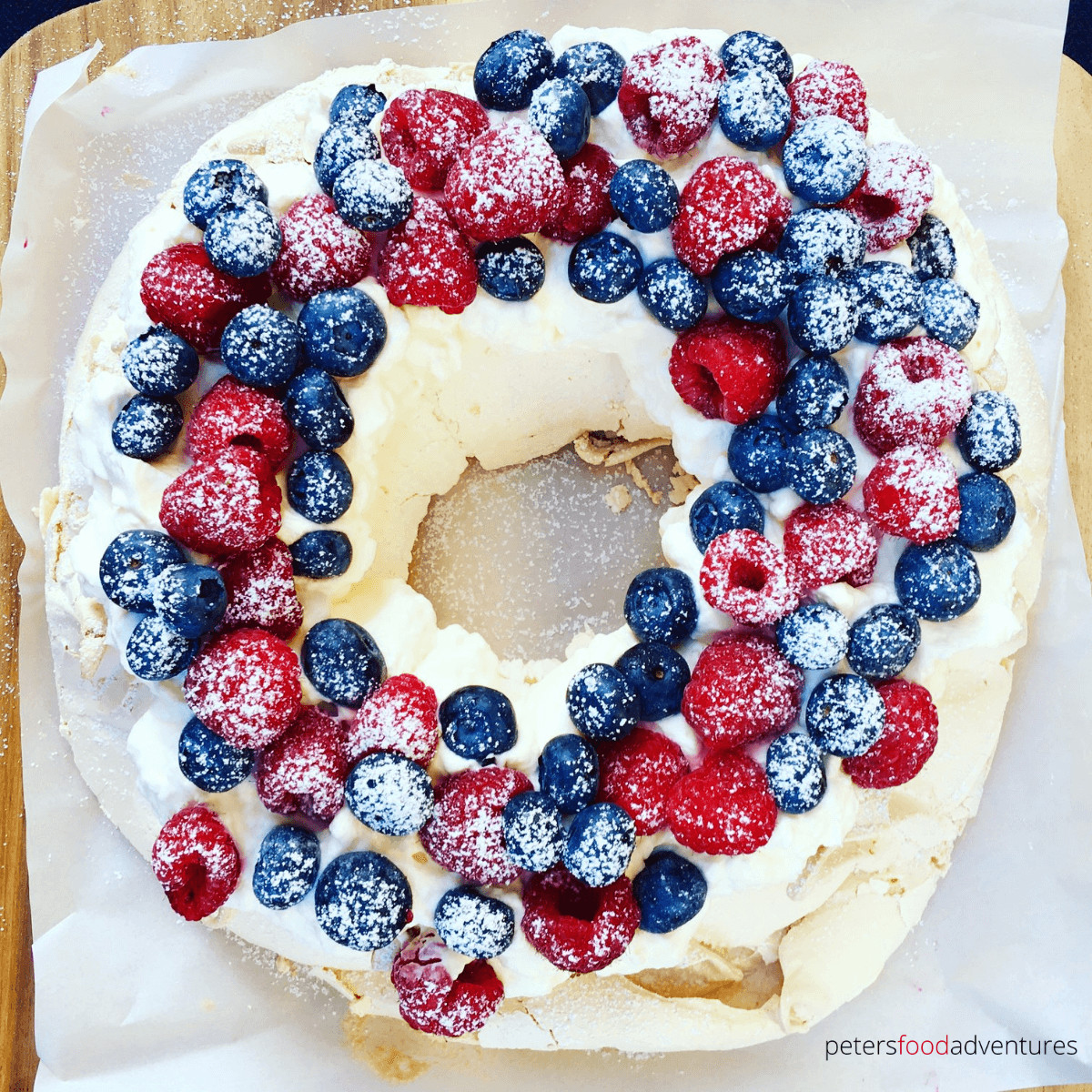 Berry Pavlova Wreath is perfect for the Christmas holidays or just to eat on a summer's day, with fresh blueberries and raspberries. Pavlova with berries is an Australian classic.