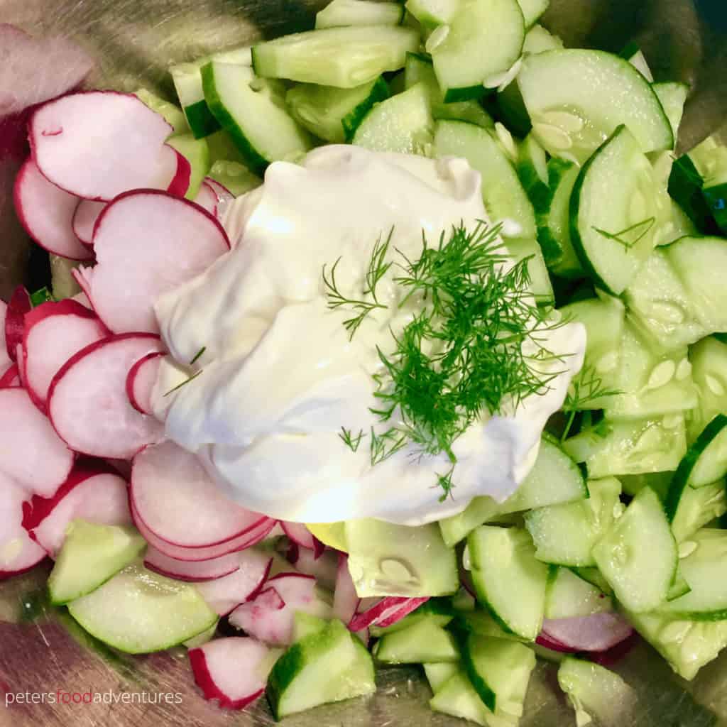 sliced cucumbers and radishes with a dollop of sour cream and dill