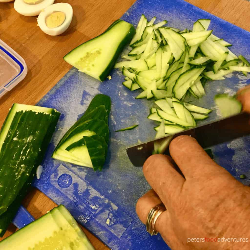 slicing cucumbers thinly for cold beet soup called holodnik