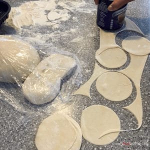 cutting dough circles for manti using a can