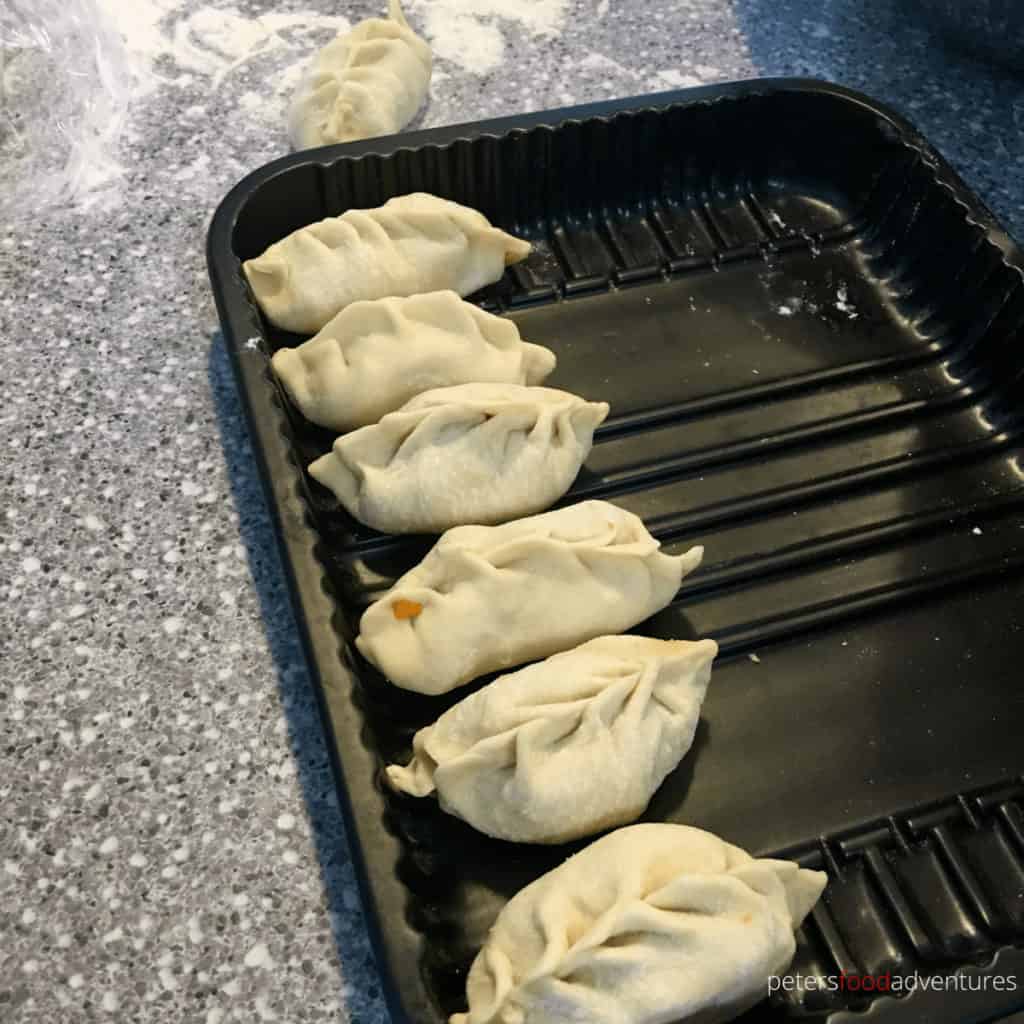 manti lined up on a tray