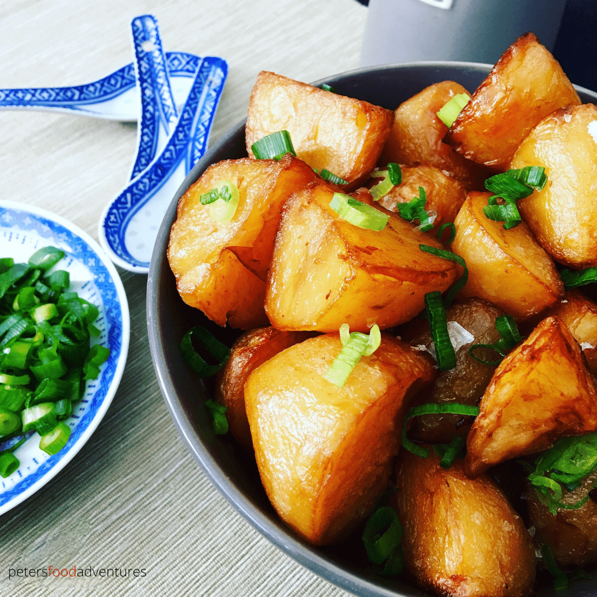asian potatoes in a bowl beside chinese spoons
