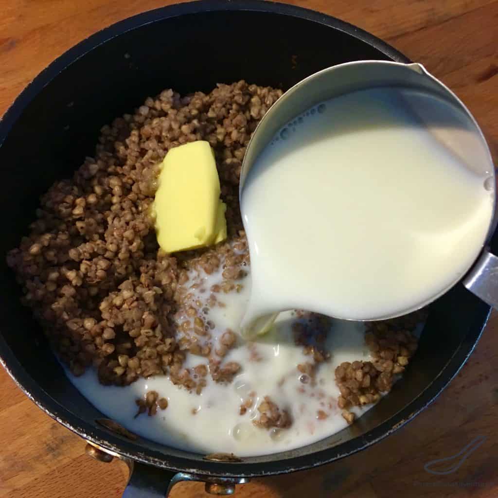 pouring milk into a pan of buckwheat