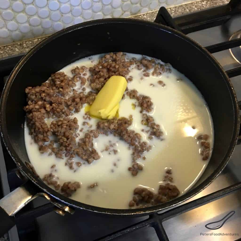 Buckwheat, milk and butter in a saucepan, making buckwheat porridge