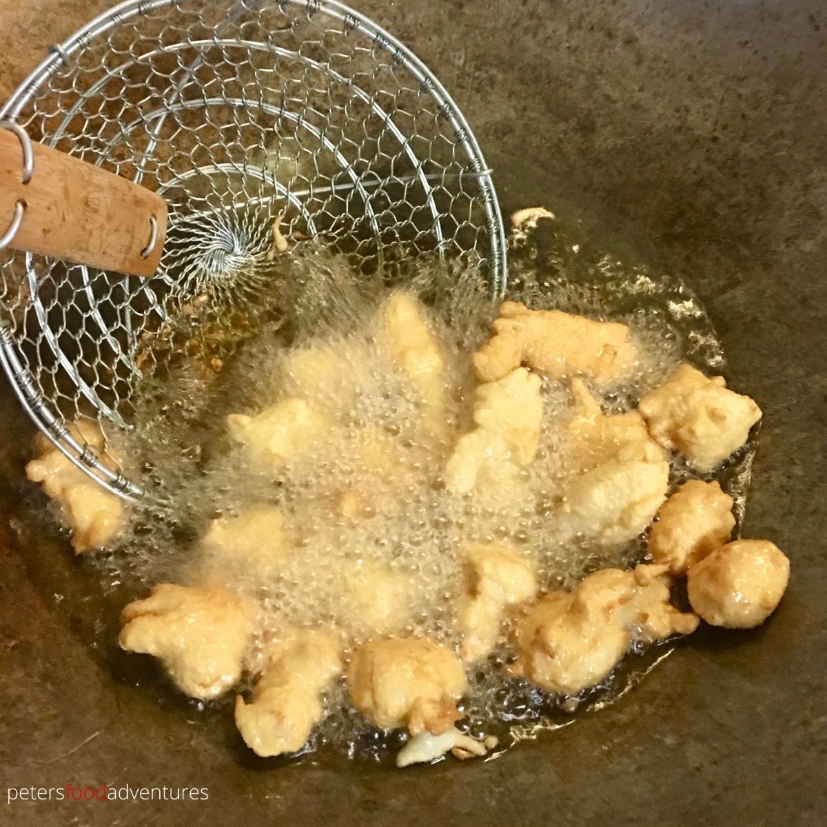 frying sesame chicken in wok
