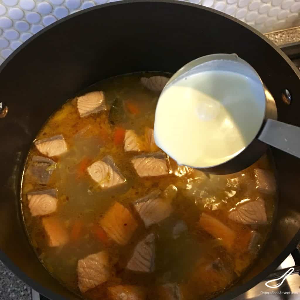 pouring cream into Finnish salmon soup