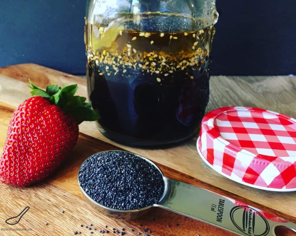 Jar of Poppy Seed Salad Dressing with a spoon of Poppy Seeds
