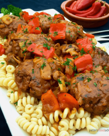 Beefy meatballs cooked with Russian gravy, mushrooms and red peppers. Comfort food that's kid friendly and delicious. Kotleti are served with pasta or mashed potatoes (Котлеты с подливкой)
