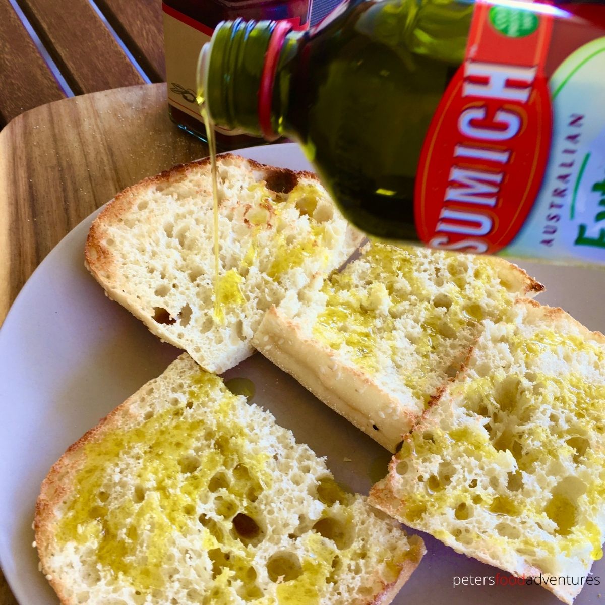 pouring olive oil on bread