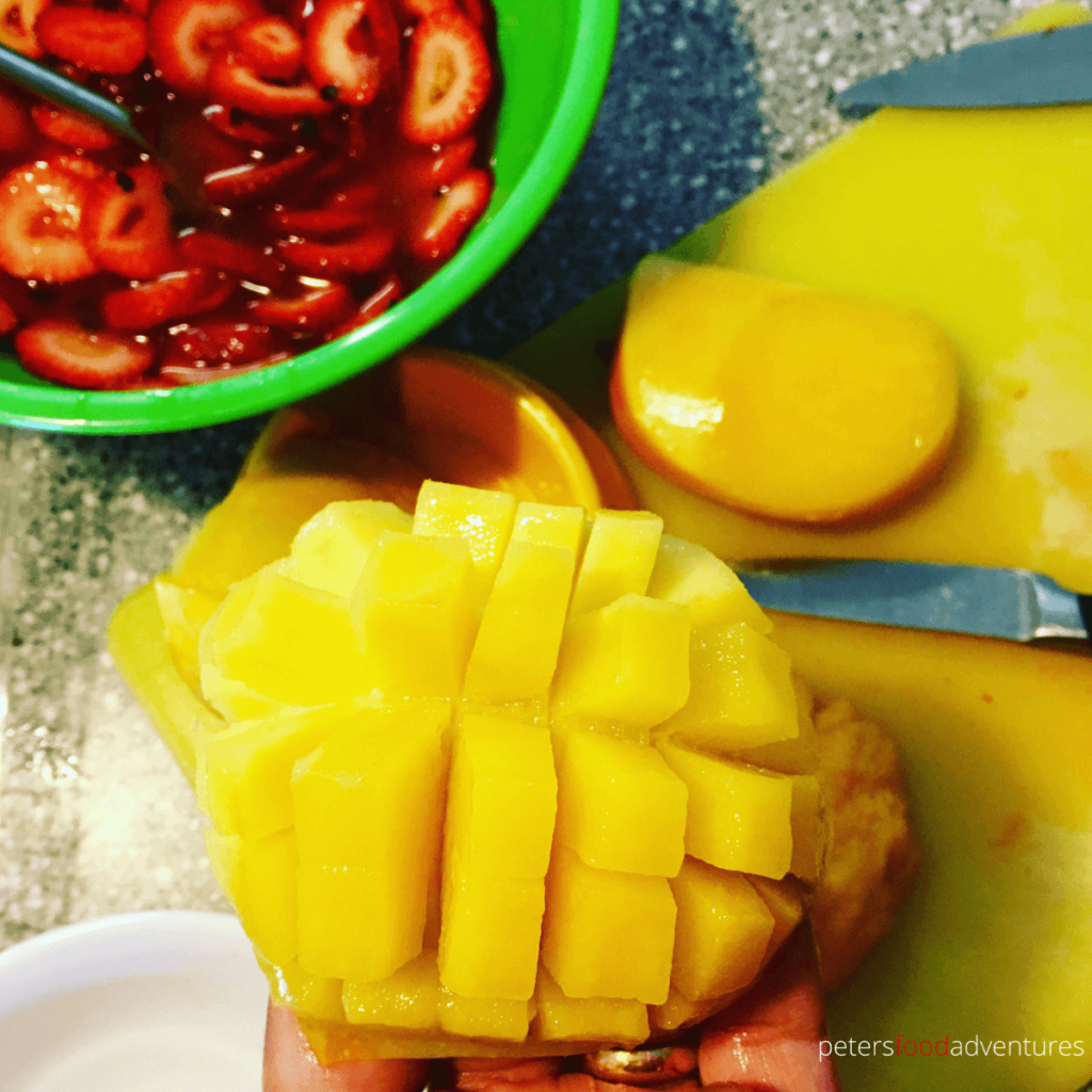 cutting a mango with a mango slicer into cross hatches