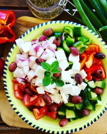 bowl of greek salad with tomatoes, feta and red peppers