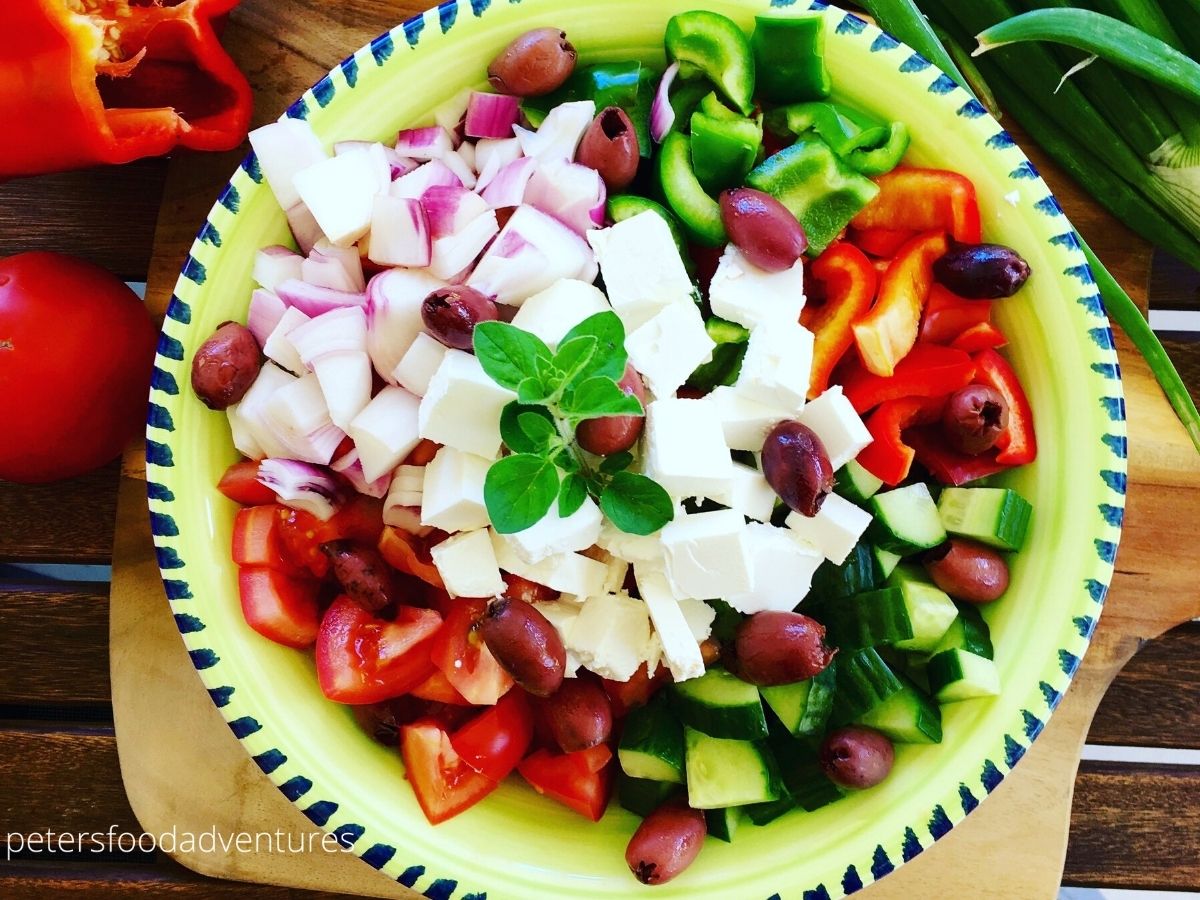 bowl of greek salad with tomatoes, onion, feta and olives
