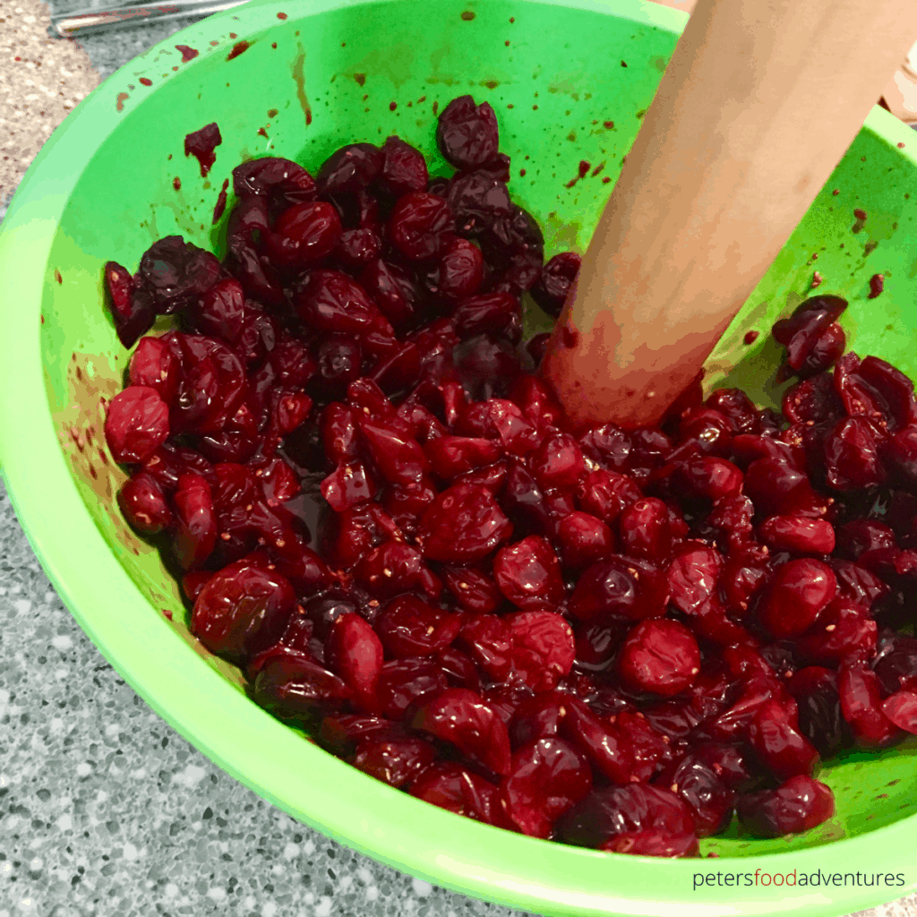 mashing cranberries in a bowl