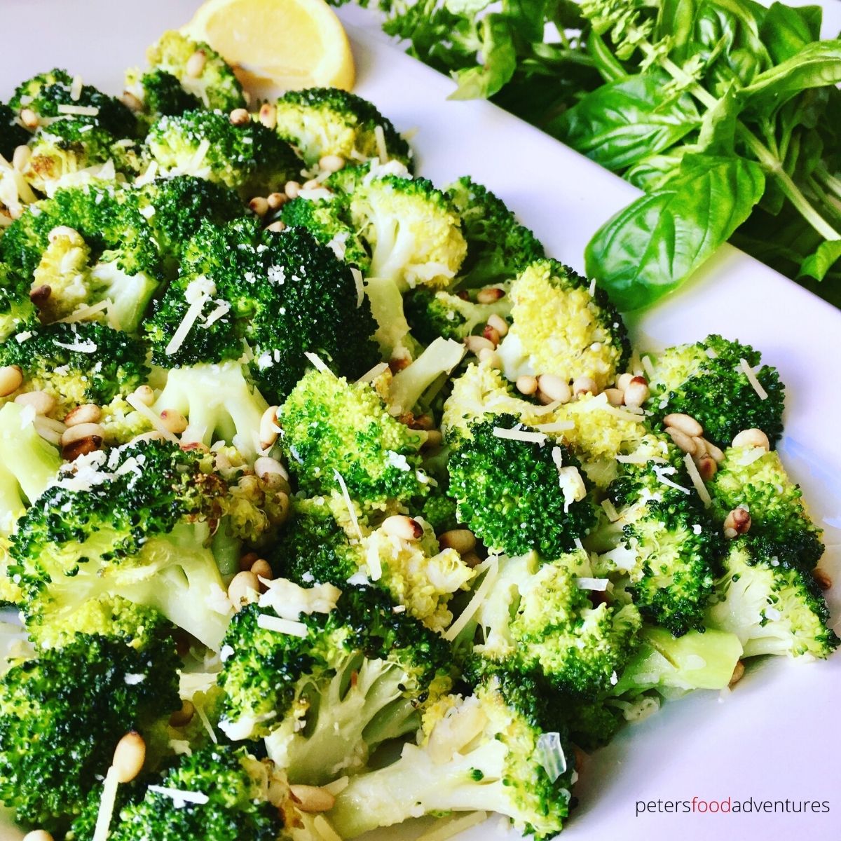 garlic roasted broccoli on a plate with pine nuts