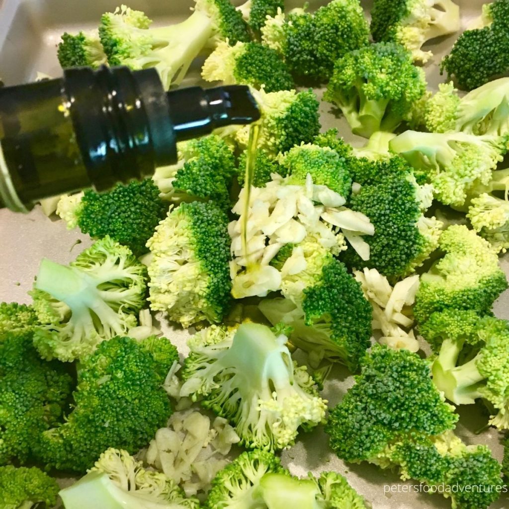pouring olive oil over raw broccoli