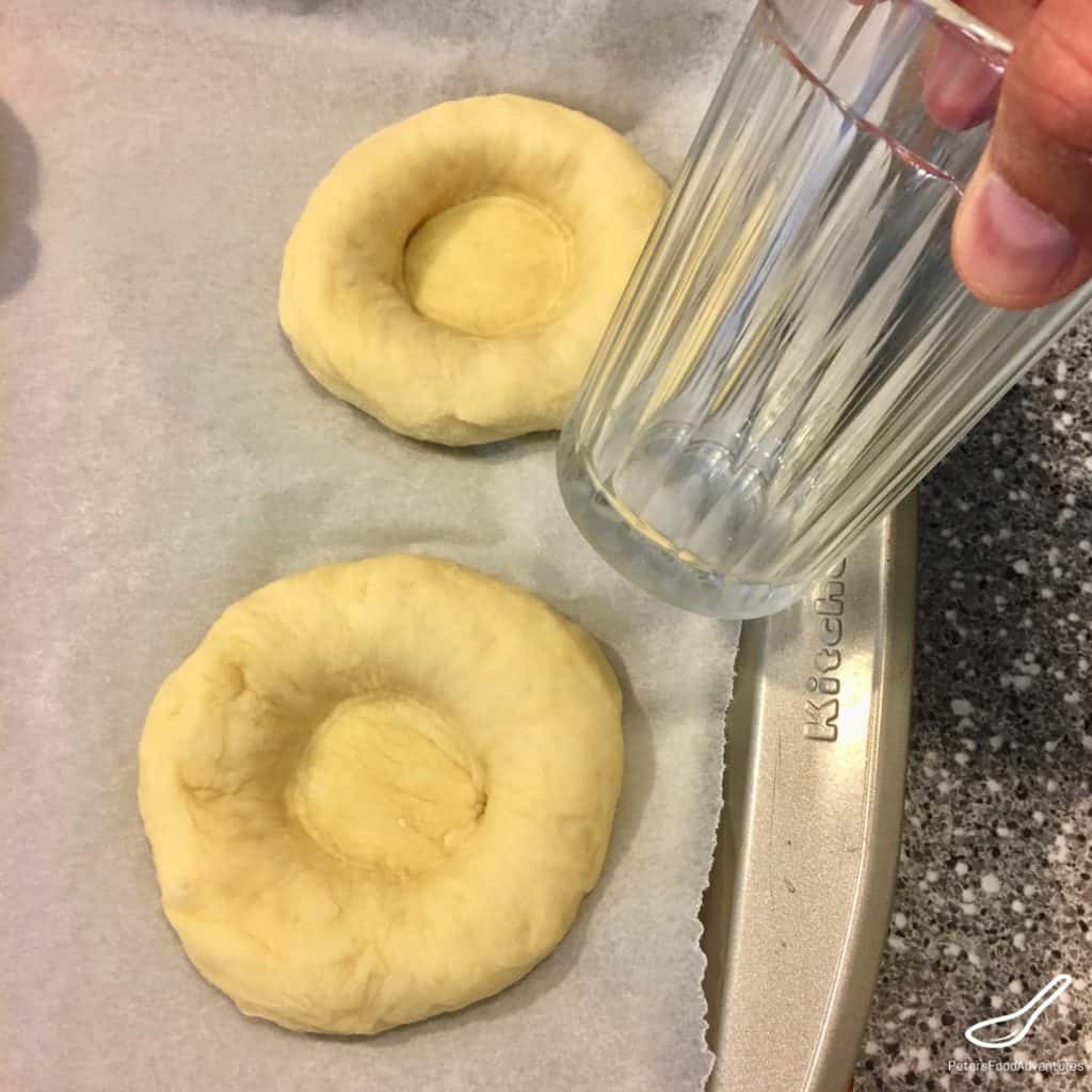 Indenting dough with a glass for vatrushka buns