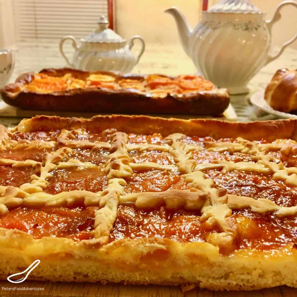 A rustic treat with sweet homemade apricot jam, generously spread on a Russian sweet yeast dough called Sdobnoe (сдобное тесто). Not your ordinary pie pastry, almost a cake or slice, so delicious and so Russian - Apricot Pirog Pie (Пирог из дрожжевого теста с вареньем)