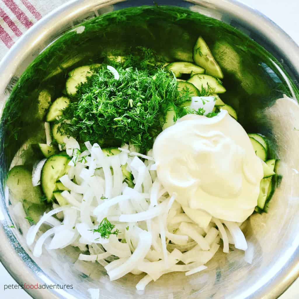 Mizeria Cucumber Salad in a bowl being prepared