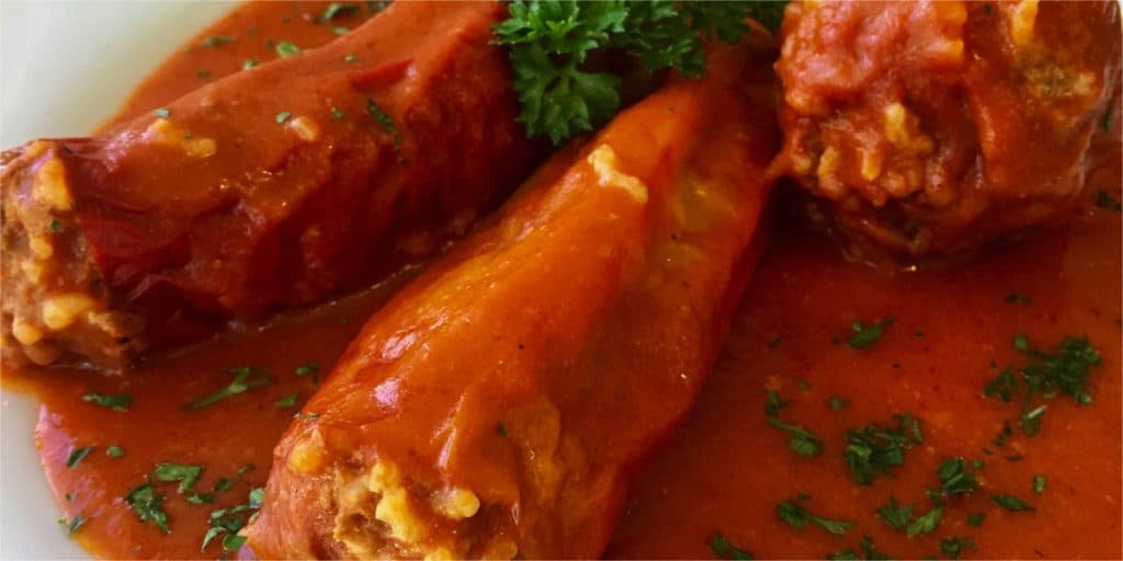 A Hungarian classic summer dish - paprika peppers with with ground beef, rice and paprika spice. Cooked in a delicious tomato passata sauce. Summer comfort food - Hungarian Stuffed Peppers (töltött paprika)