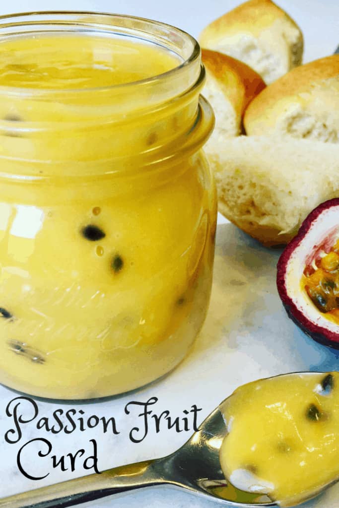 Passion Fruit Curd in a glass jar with a spoon of passionfruit butter on the table