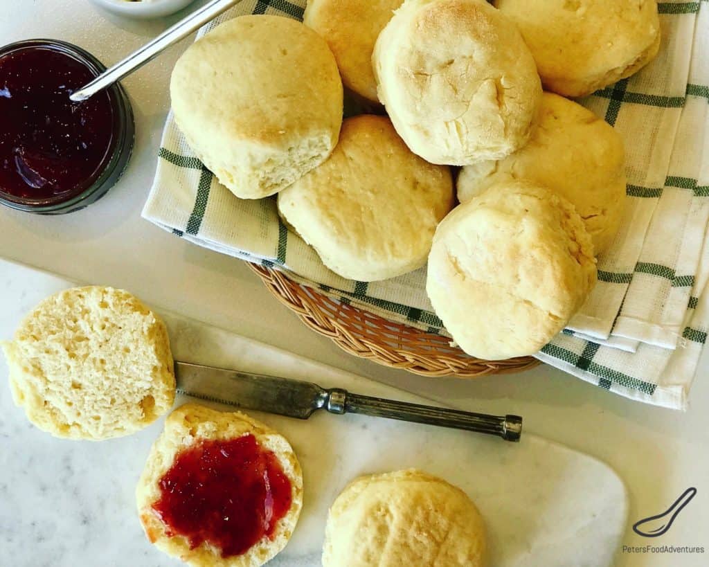 Top view of scones in a basket, spread with strawberry jam