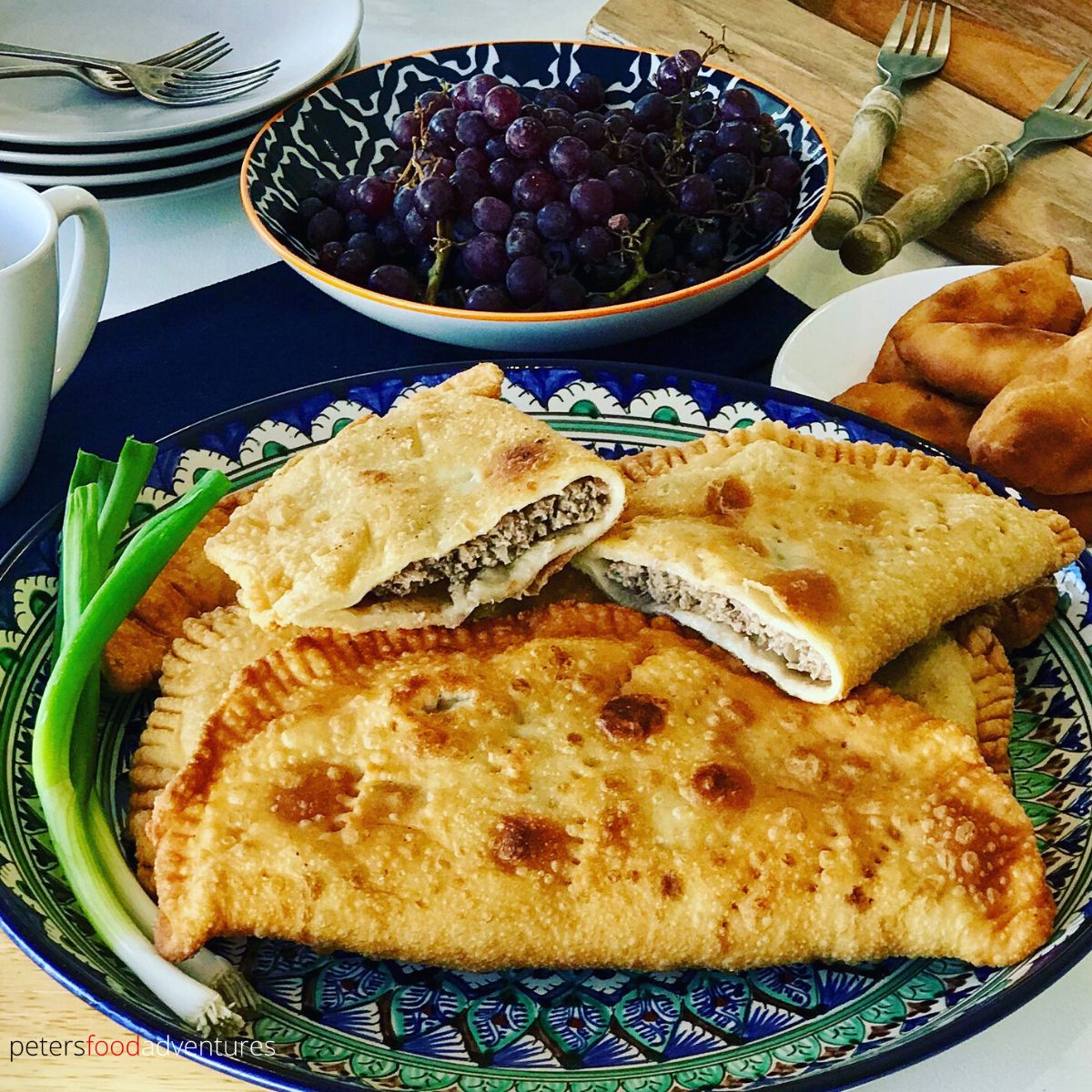 chebureki on a plate, with filling exposed