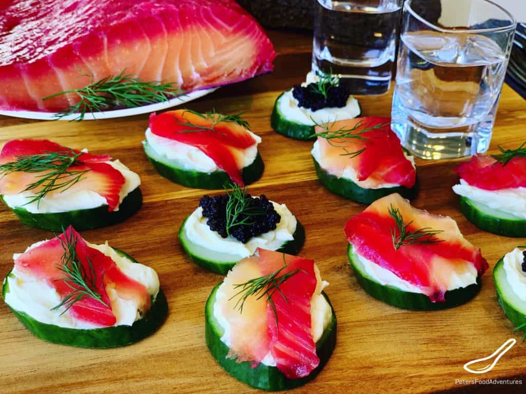 Cucumber Appetizers with Salmon and caviar on a wooden board, with a shot of vodka