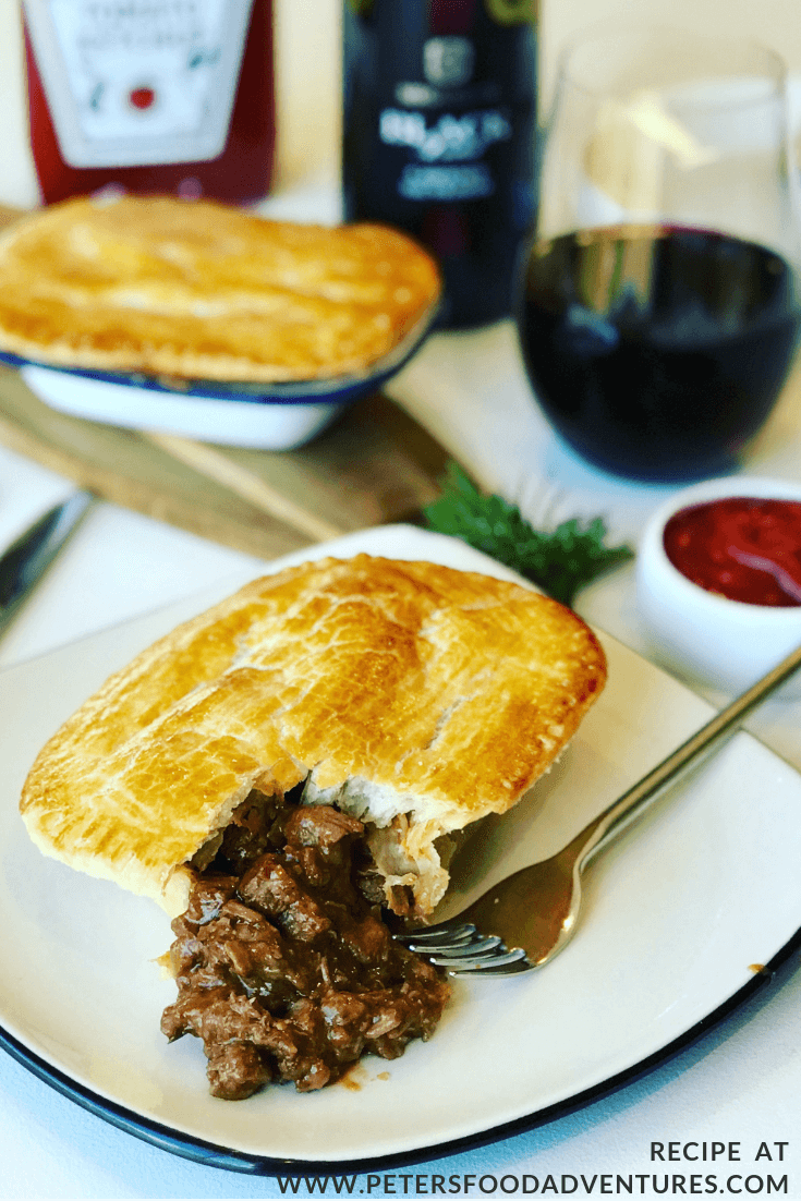 australian meat pies on a table with red wine
