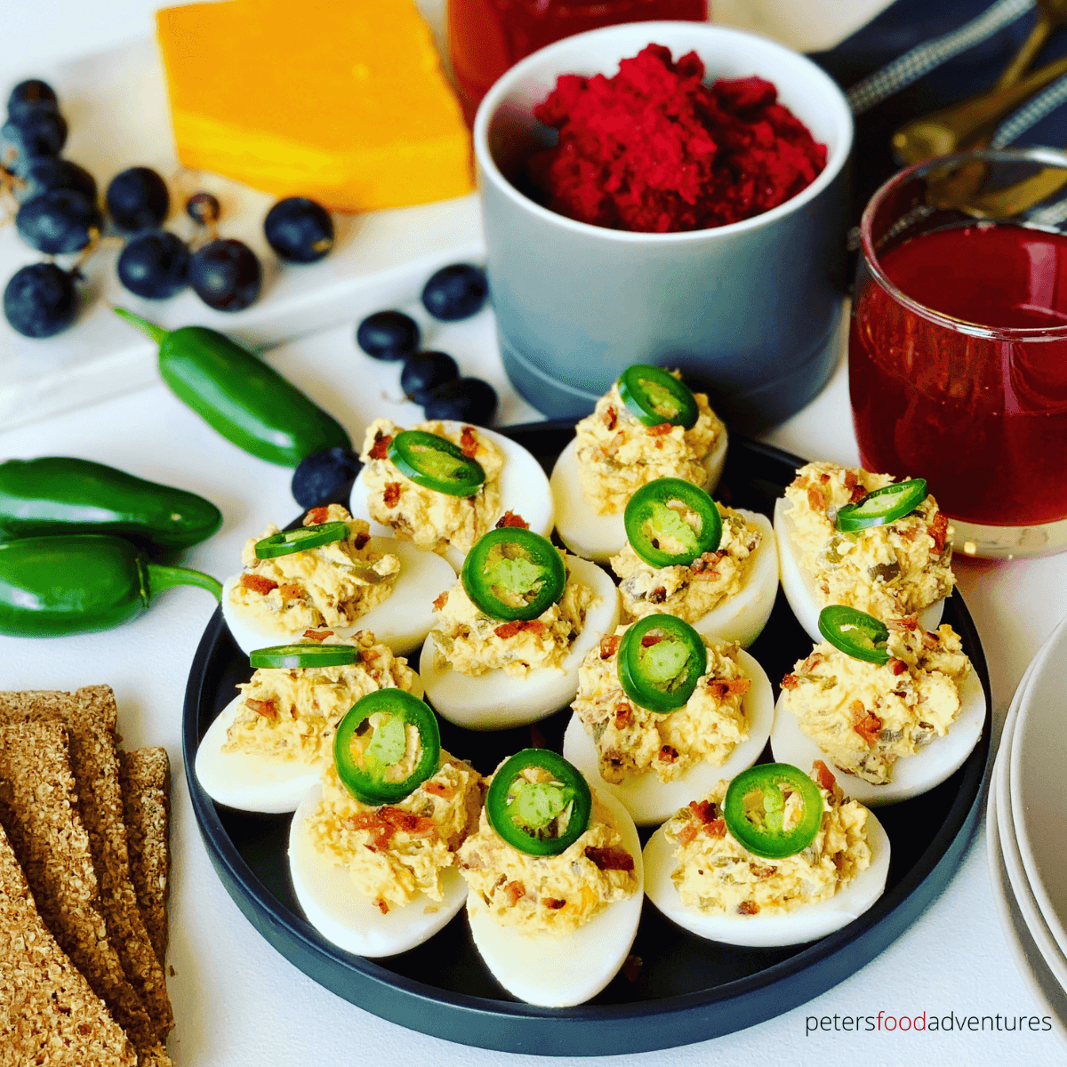 Jalapeno Popper Deviled Eggs are a low carb appetizer that everyone will love. Stuffed with cream cheese, bacon, cheddar and 3 types of jalapenos. These spicy devilled eggs pack a punch! The perfect appetizer for Easter, Super Bowl, Christmas or any holiday celebration or potluck.