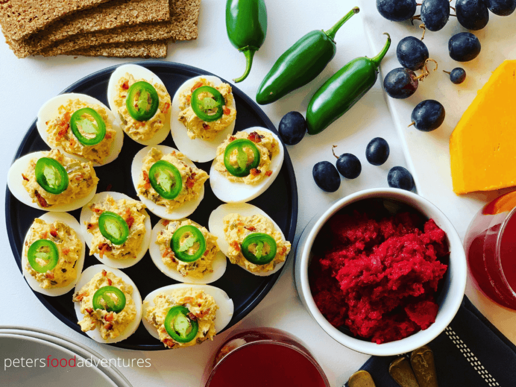 Jalapeno Popper Deviled Eggs are a low carb appetizer that everyone will love. Stuffed with cream cheese, bacon, cheddar and 3 types of jalapenos. These spicy devilled eggs pack a punch! The perfect appetizer for Easter, Super Bowl, Christmas or any holiday celebration or potluck.