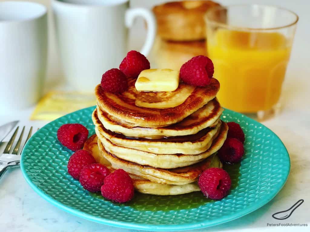 Pancake stack with fresh raspberries and maple syrup