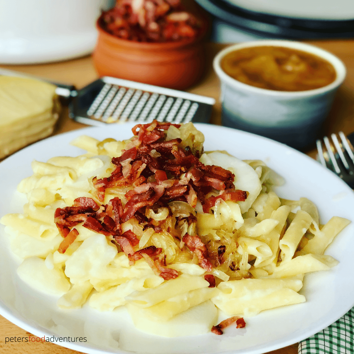 Aelplermagronen - Swiss Mac and Cheese is the ultimate Alpine comfort food. Macaroni, Swiss cheese, potatoes, caramelized onions, and bacon, served with apple sauce. Your family will love this dinner recipe! Swiss Mac and Cheese with Potatoes (Älplermagronen)