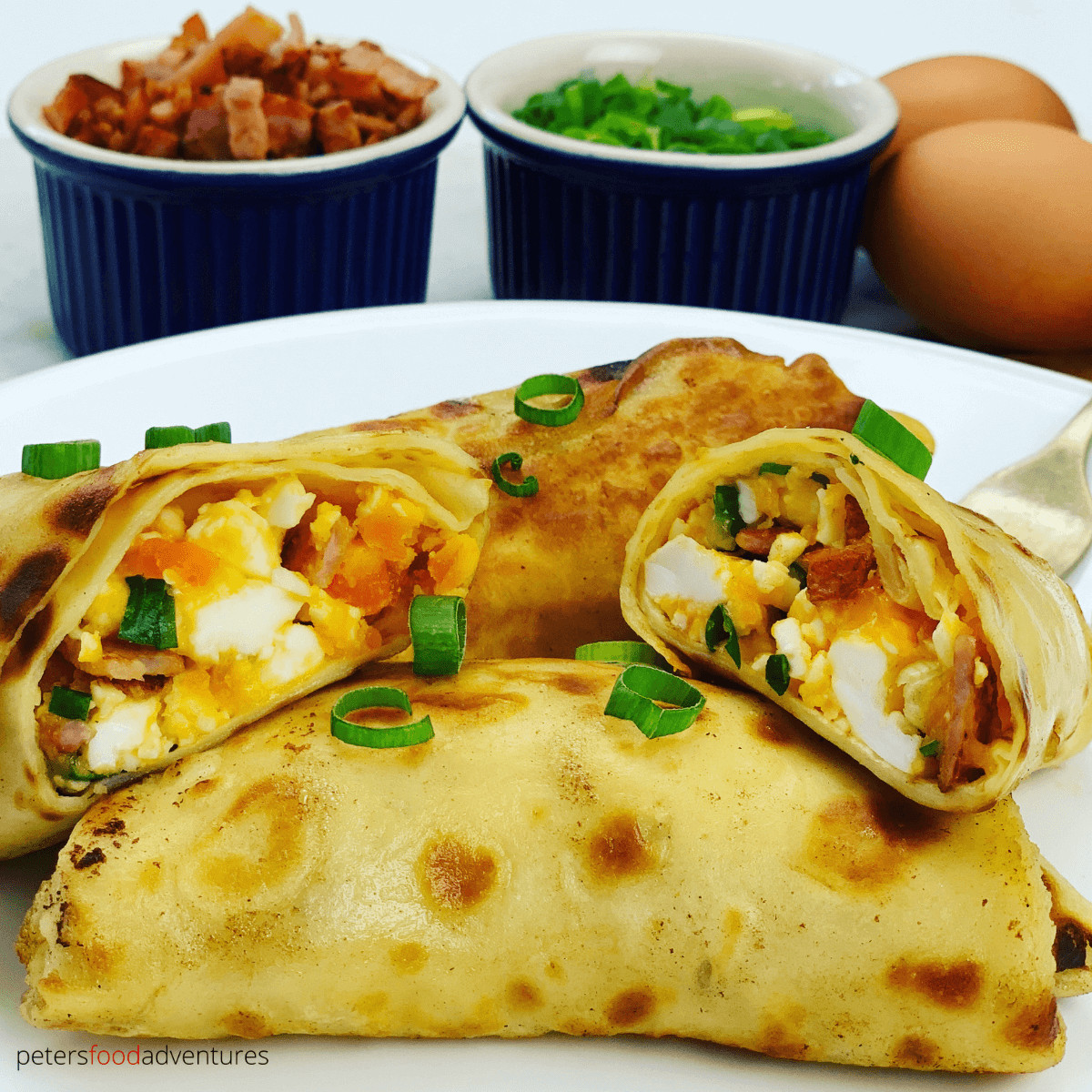 Delicious Breakfast Crepes stuffed with mediium-boiled eggs, bacon, cheese and green onions before being pan fried in butter. Generously slathered in sour cream - these savory crepes are worth the effort!