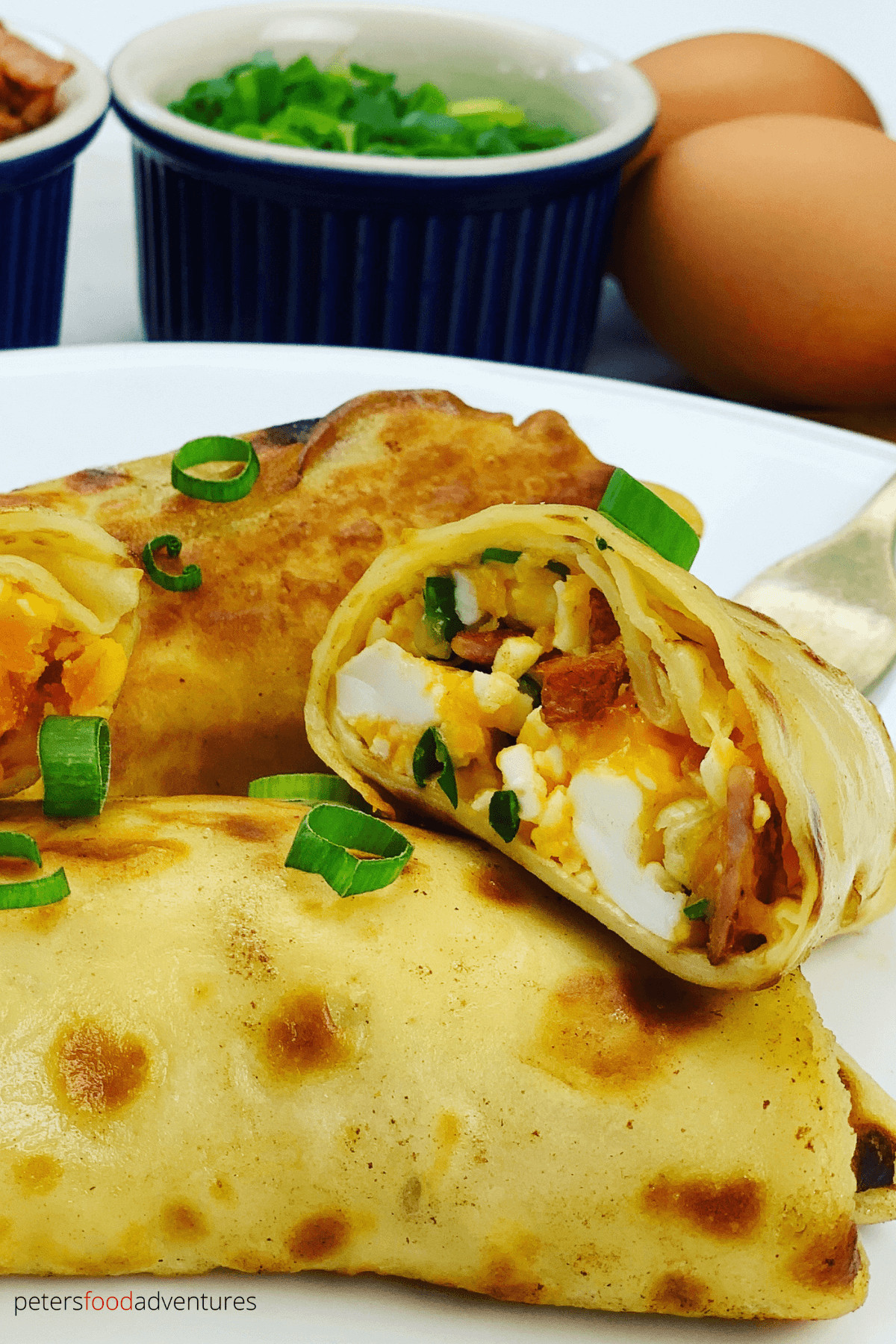 Delicious Breakfast Crepes stuffed with mediium-boiled eggs, bacon, cheese and green onions before being pan fried in butter. Generously slathered in sour cream - these savory crepes are worth the effort!