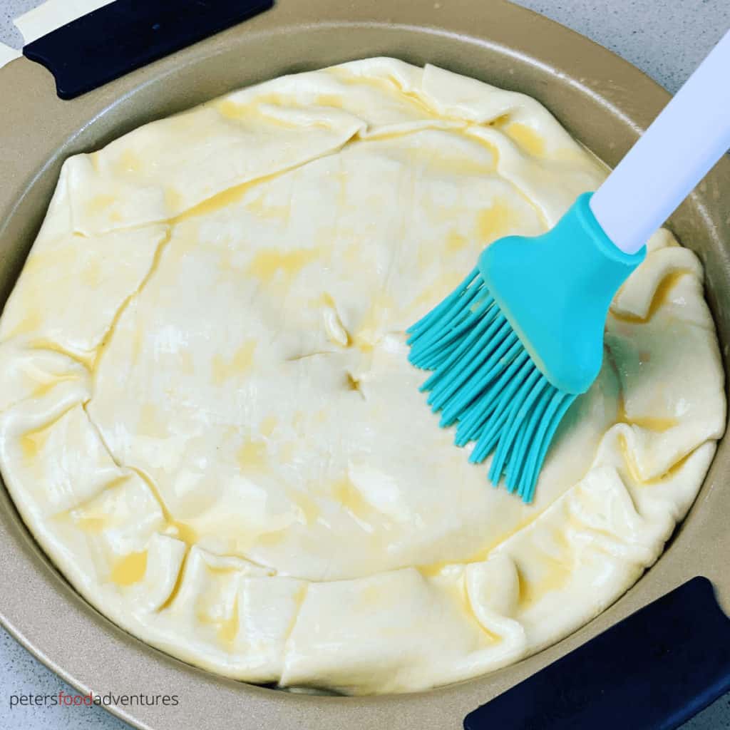 brushing egg wash on cabbage pie