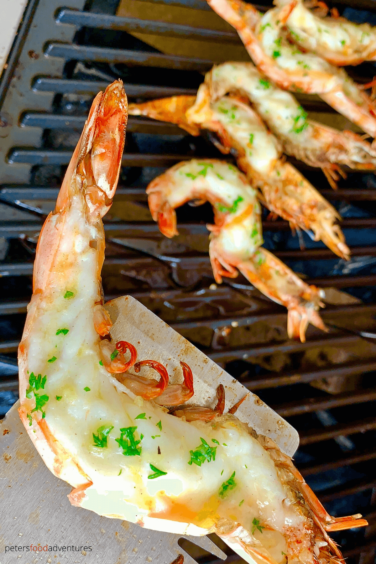 Grilled King Prawns generously slathered in garlic butter, grilled to perfection! Butterflied Shrimp on the half shell is the perfect summer bbq feast!
