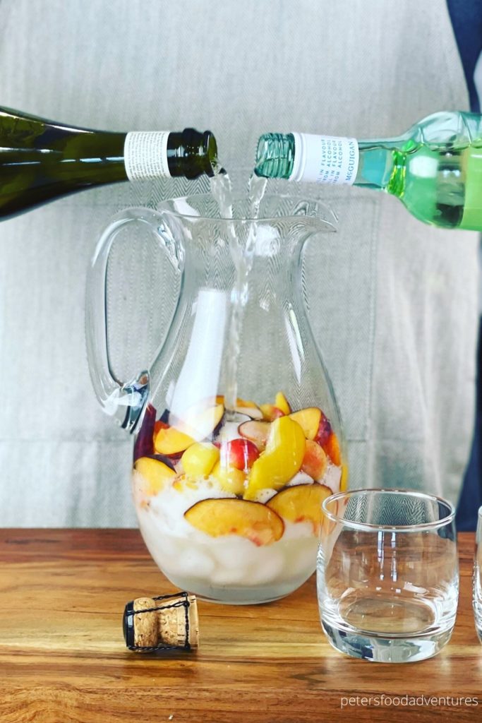 pouring wine into pitcher of peaches