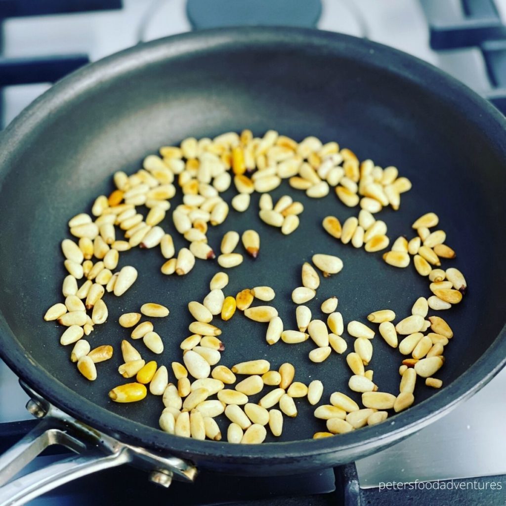 toasting pine nuts in a skillet