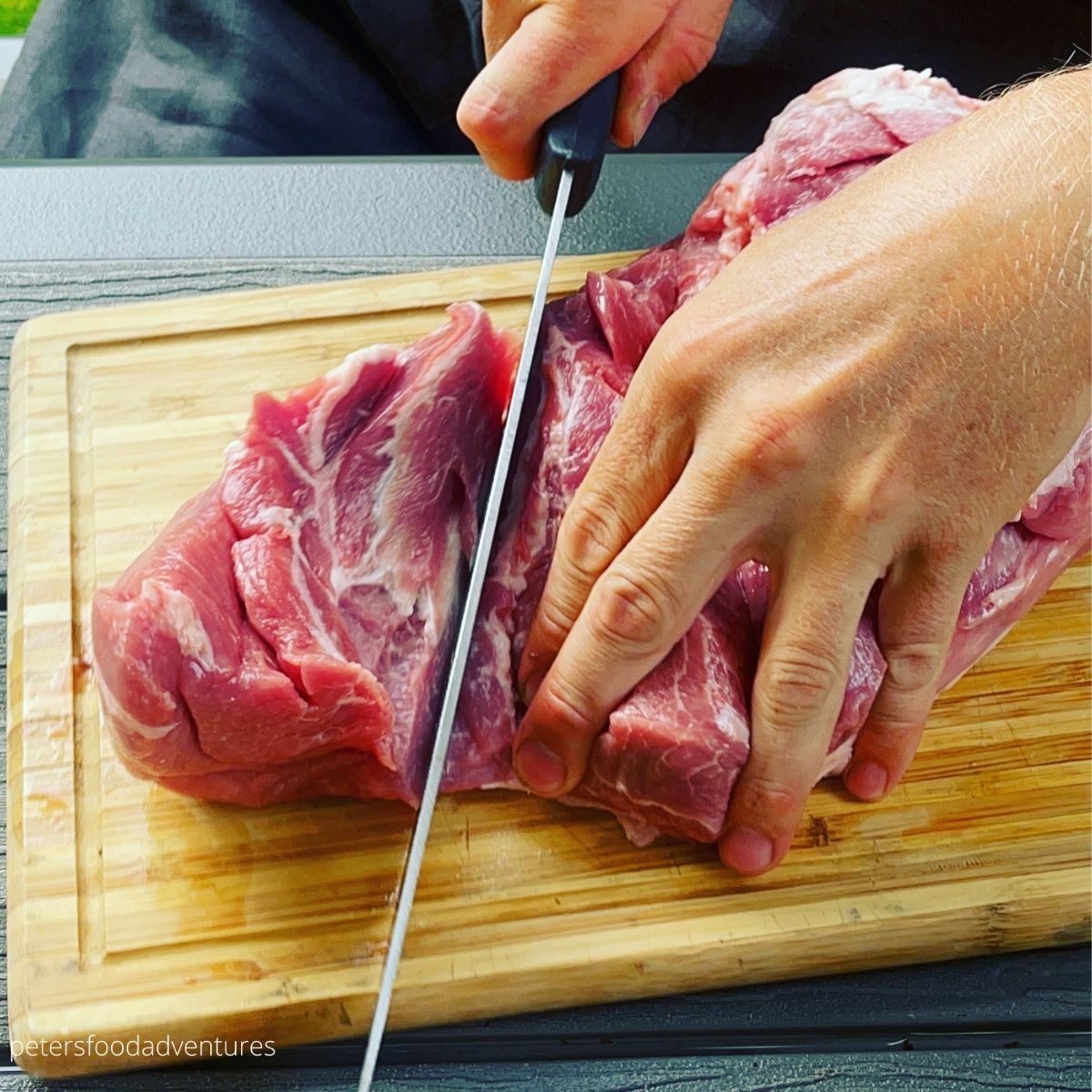 slicing pork shoulder with a knife